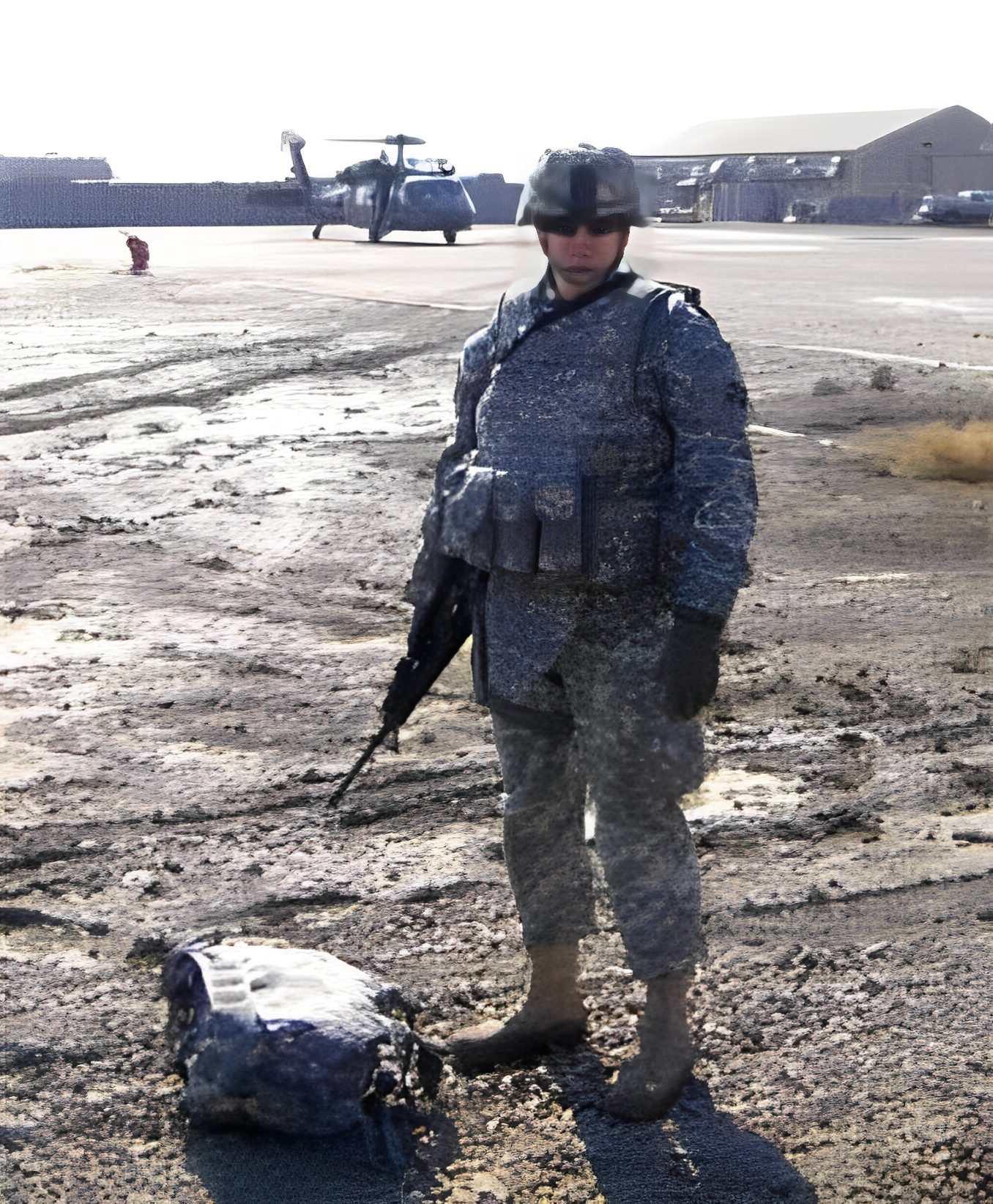 Soldier standing on airfield with helicopter behind.