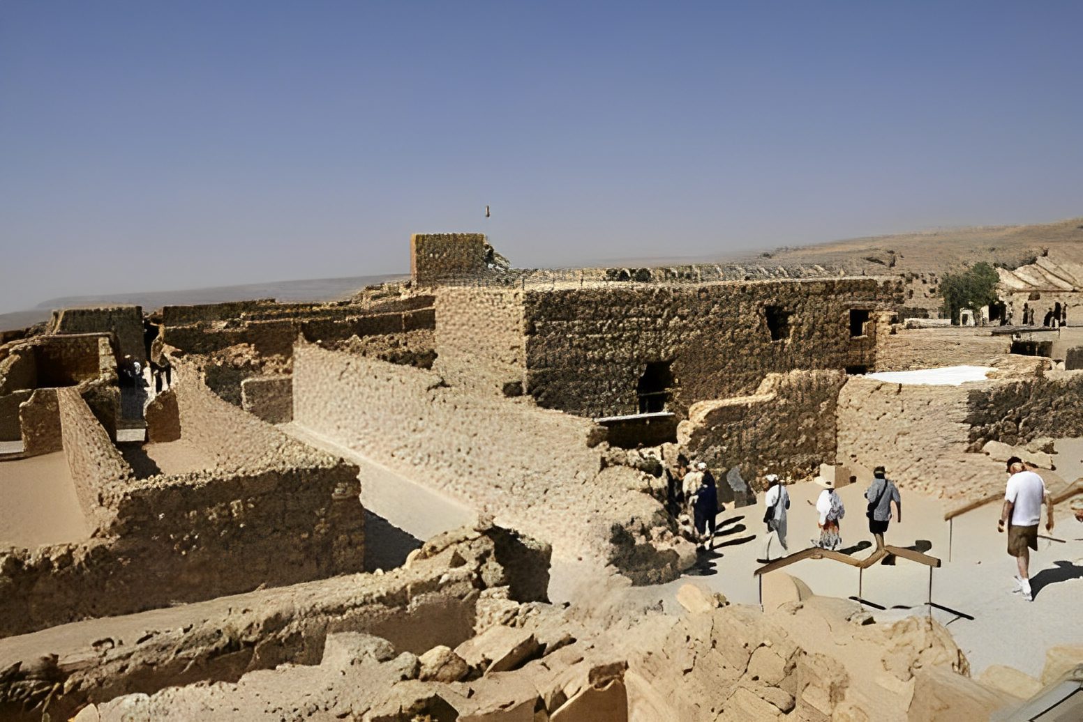 Ancient stone ruins with visiting tourists.