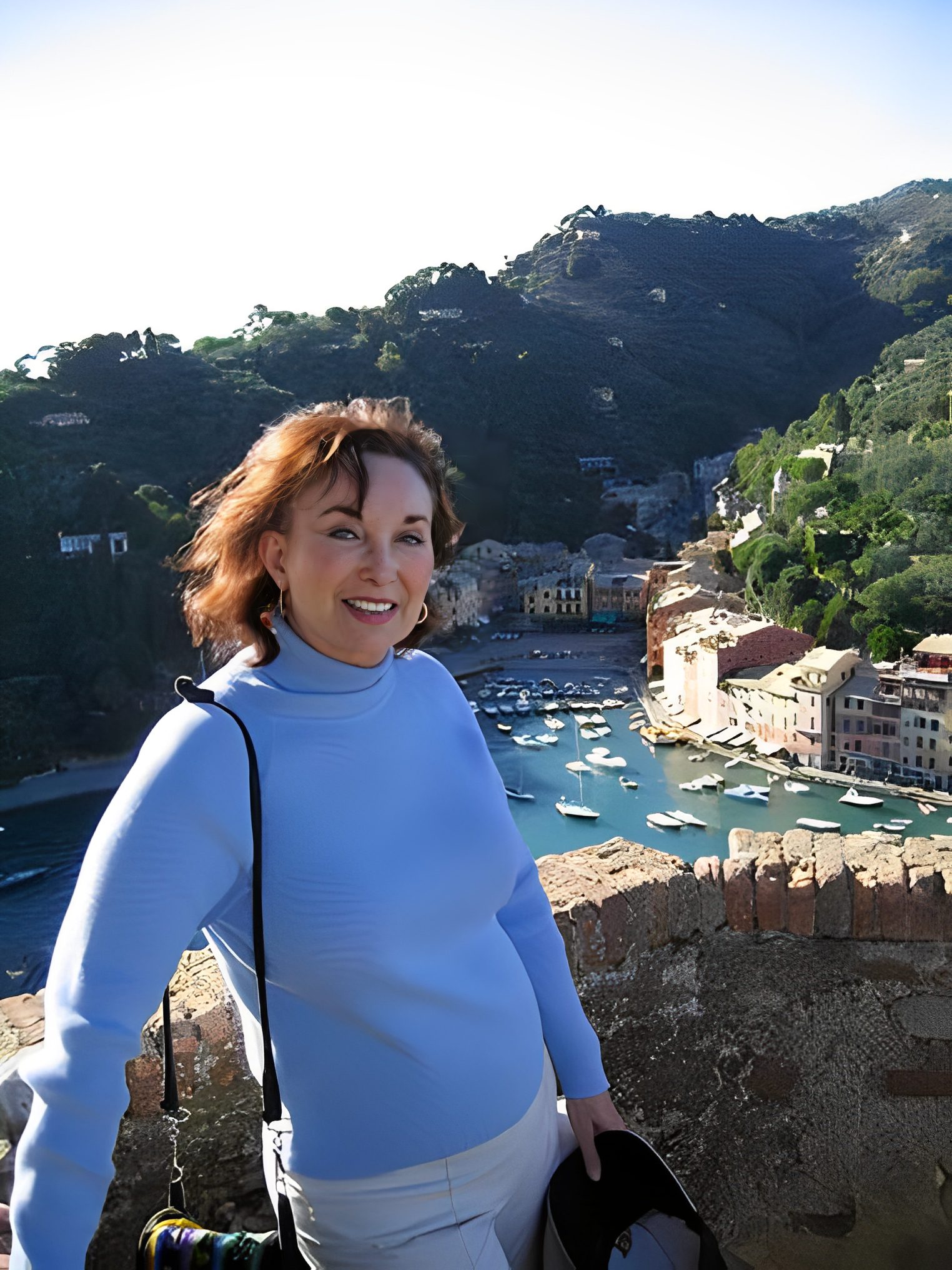 Woman smiling with scenic harbor view.