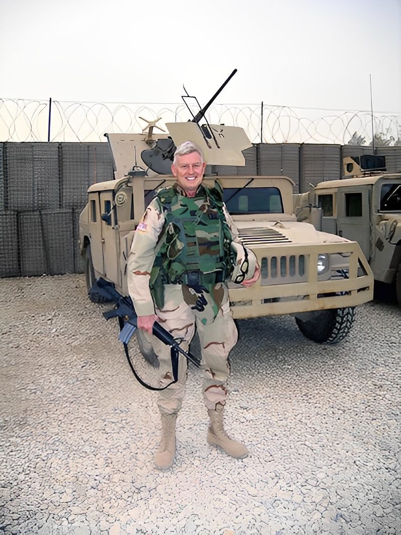 Soldier standing in front of military vehicle.