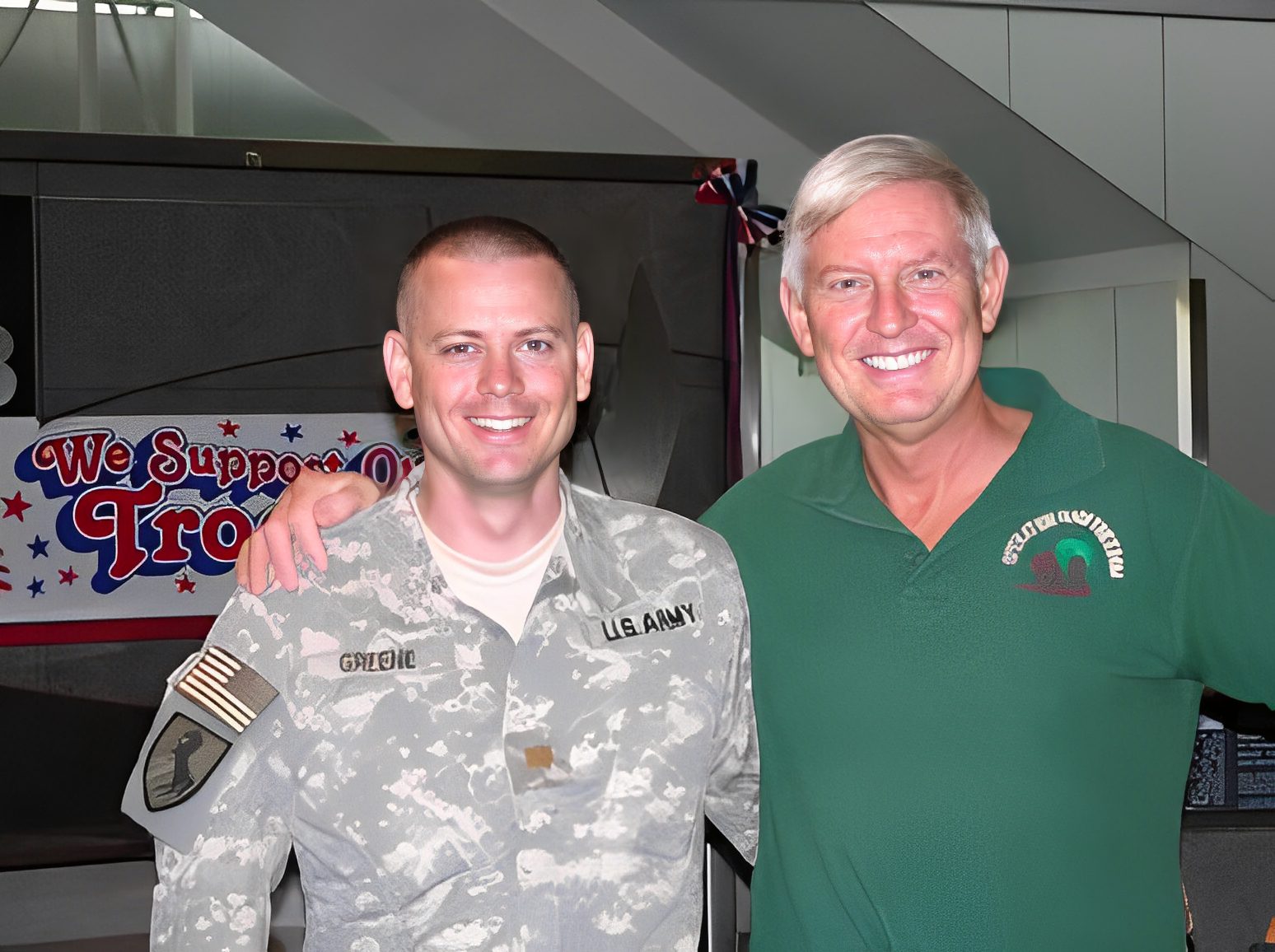 Soldier and man smiling at support event.
