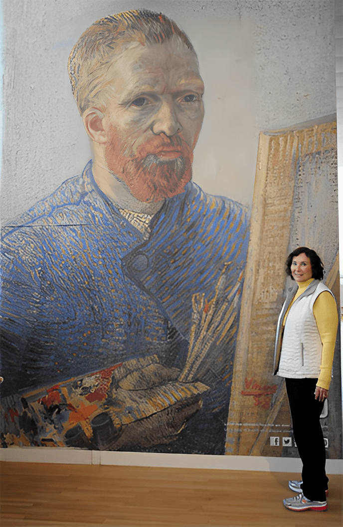 Woman standing beside large portrait painting.