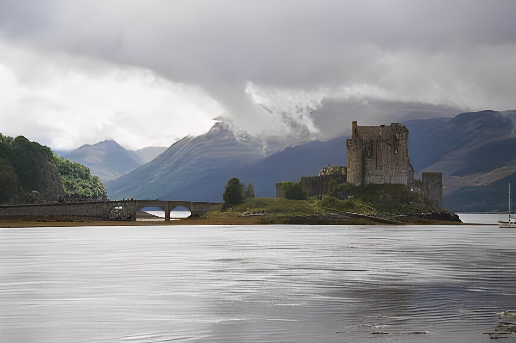 Castle on lake with mountainous backdrop.