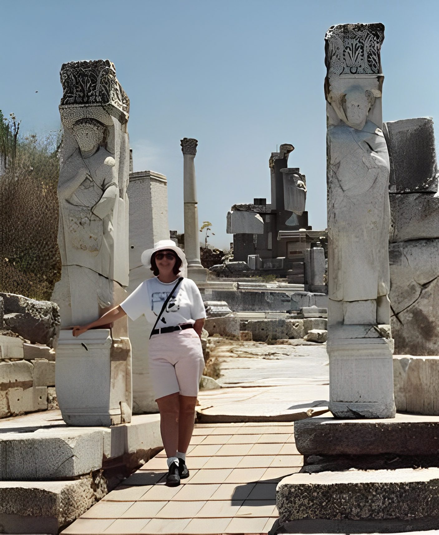 Person standing between ancient stone pillars.