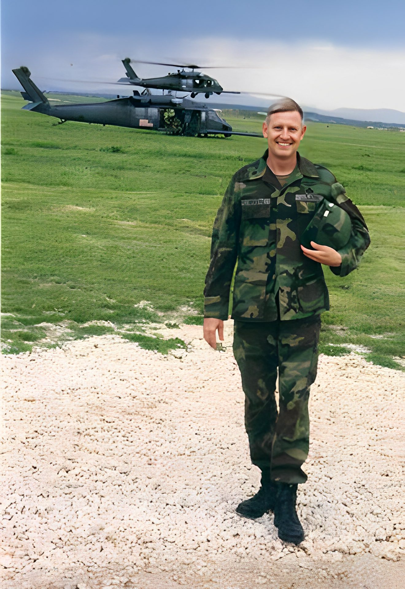 Soldier in camouflage standing near helicopter.