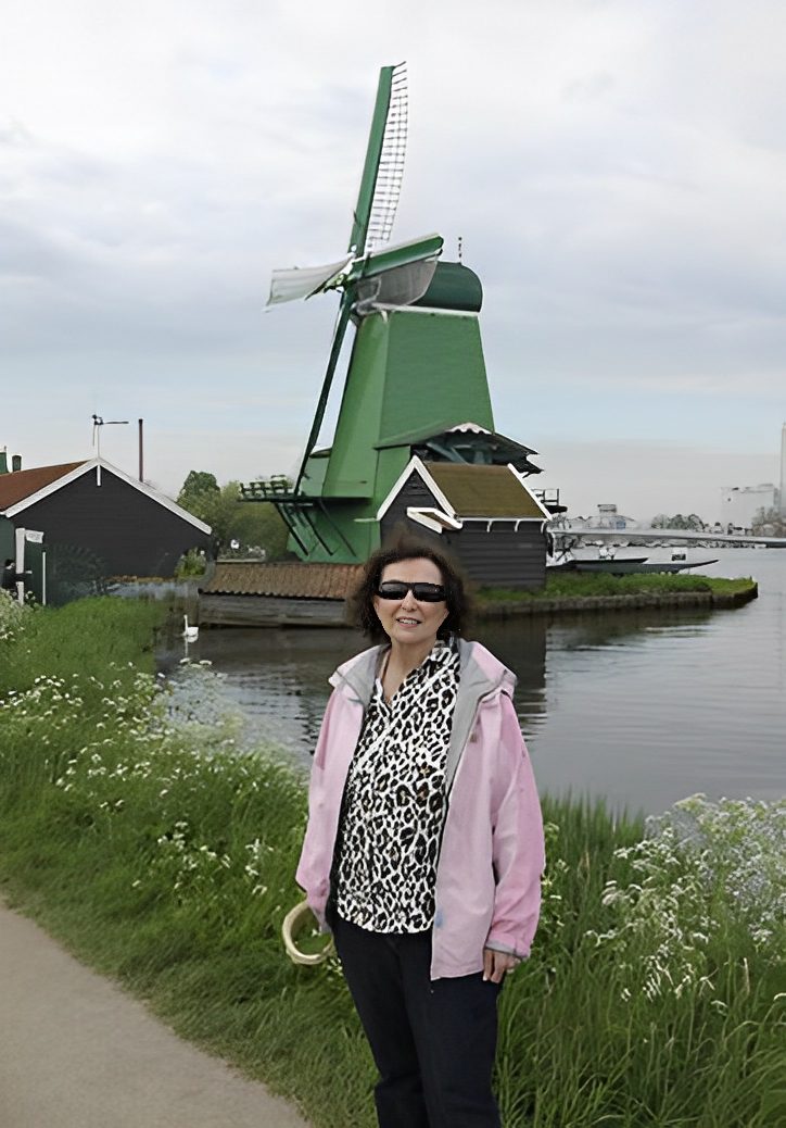 Person posing near a Dutch windmill.