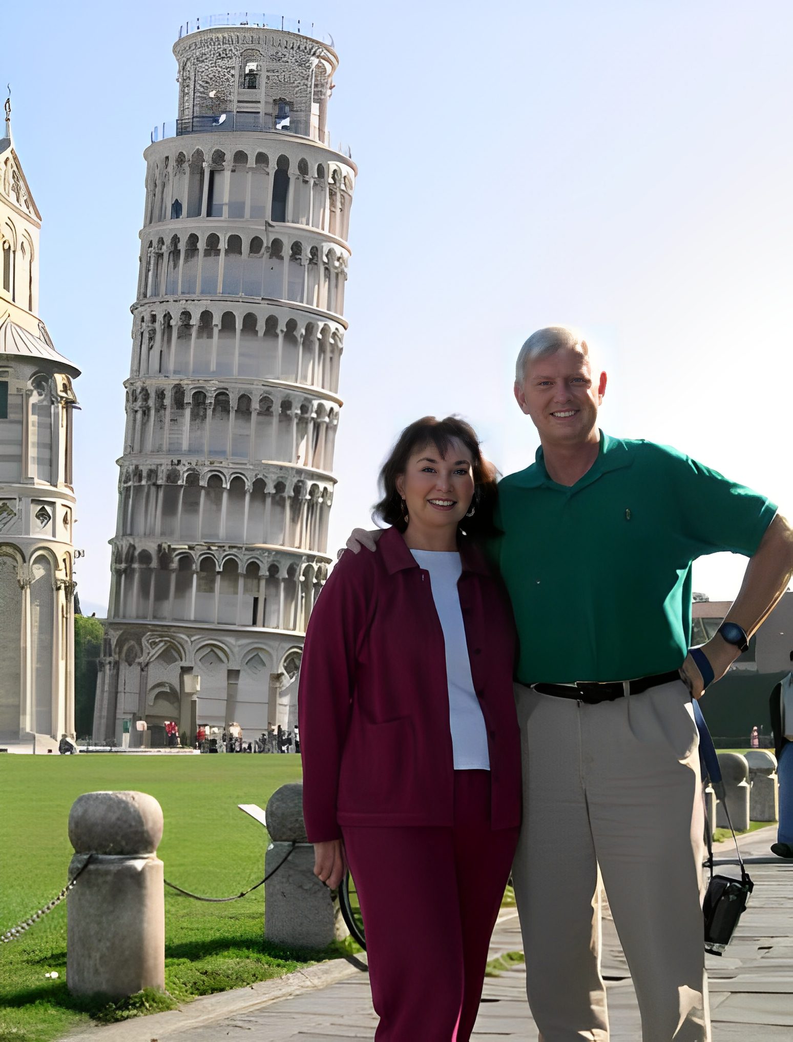 Couple posing near Leaning Tower of Pisa.