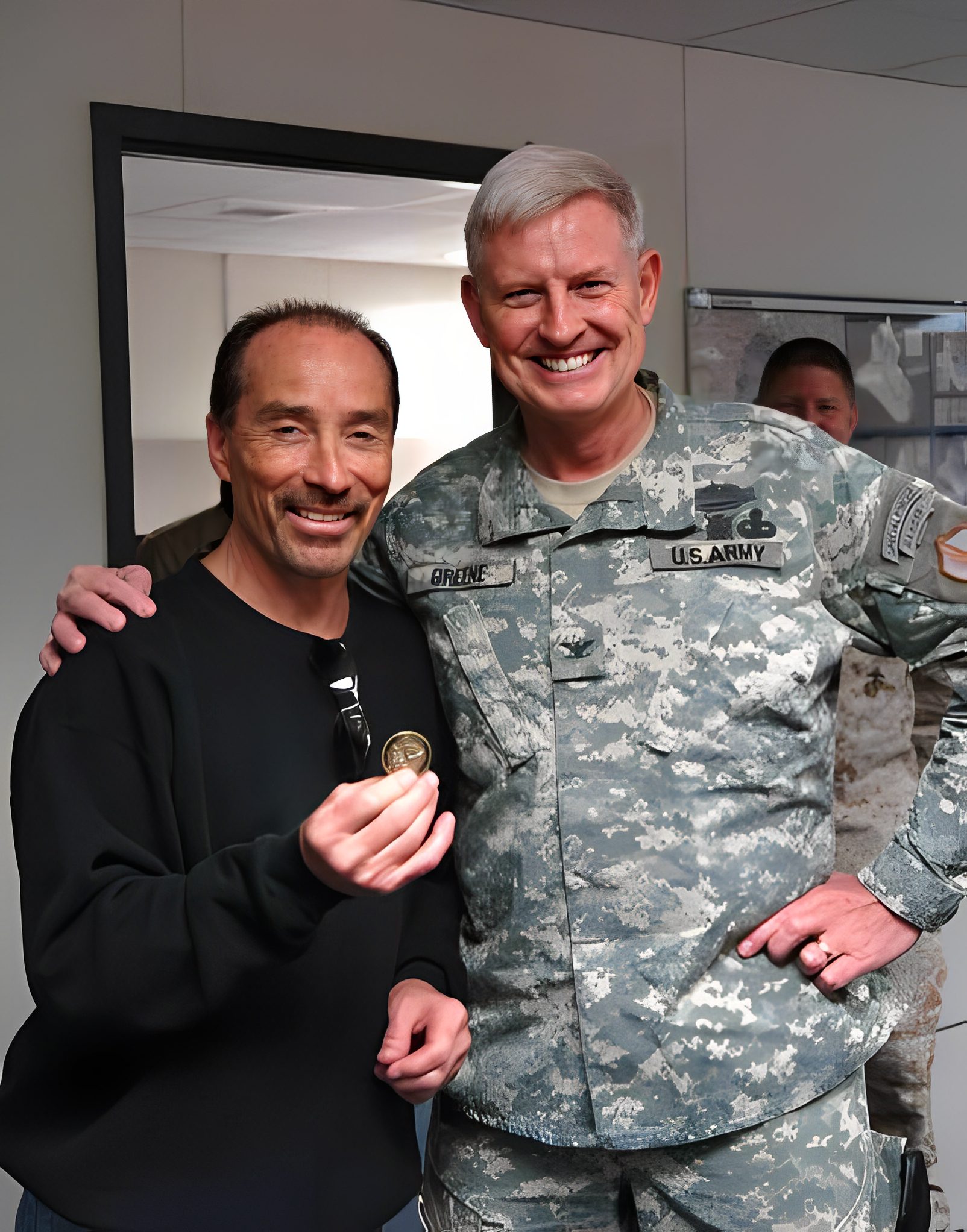 Man holding coin with army officer smiling.