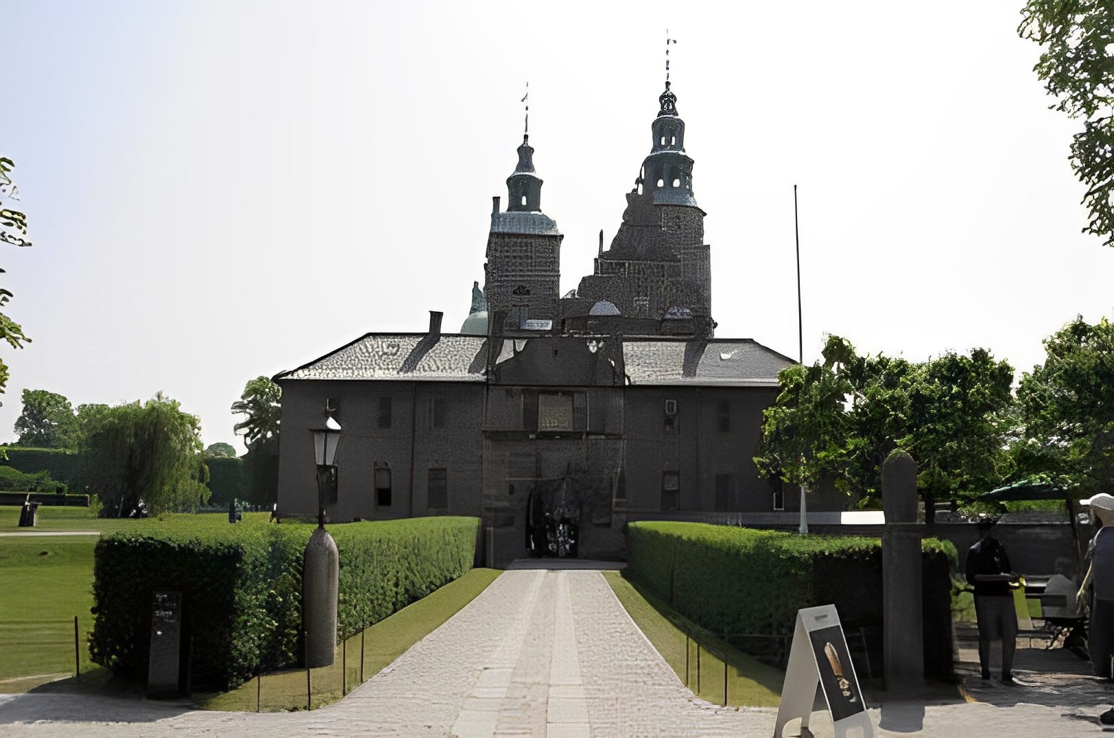 Historic castle with towers and manicured gardens.