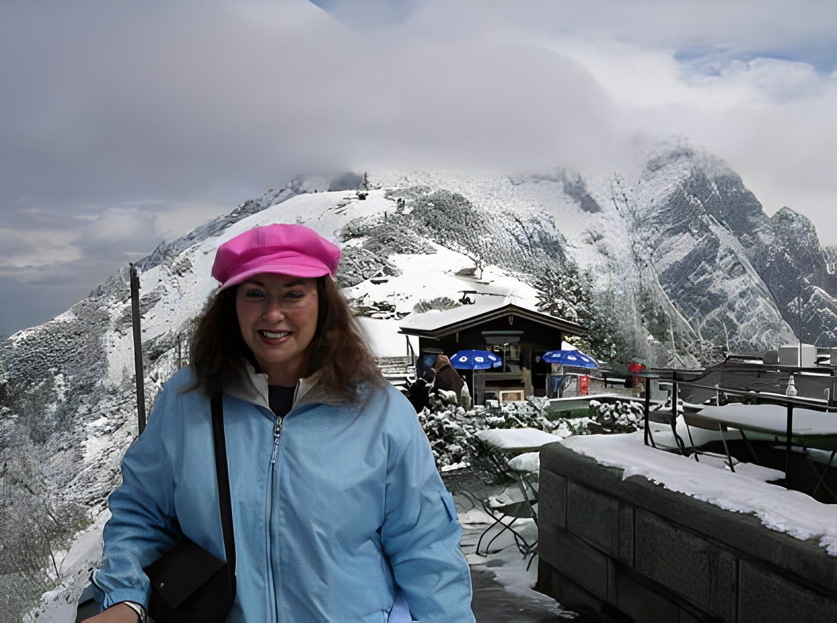 Woman smiling in snowy mountain landscape.