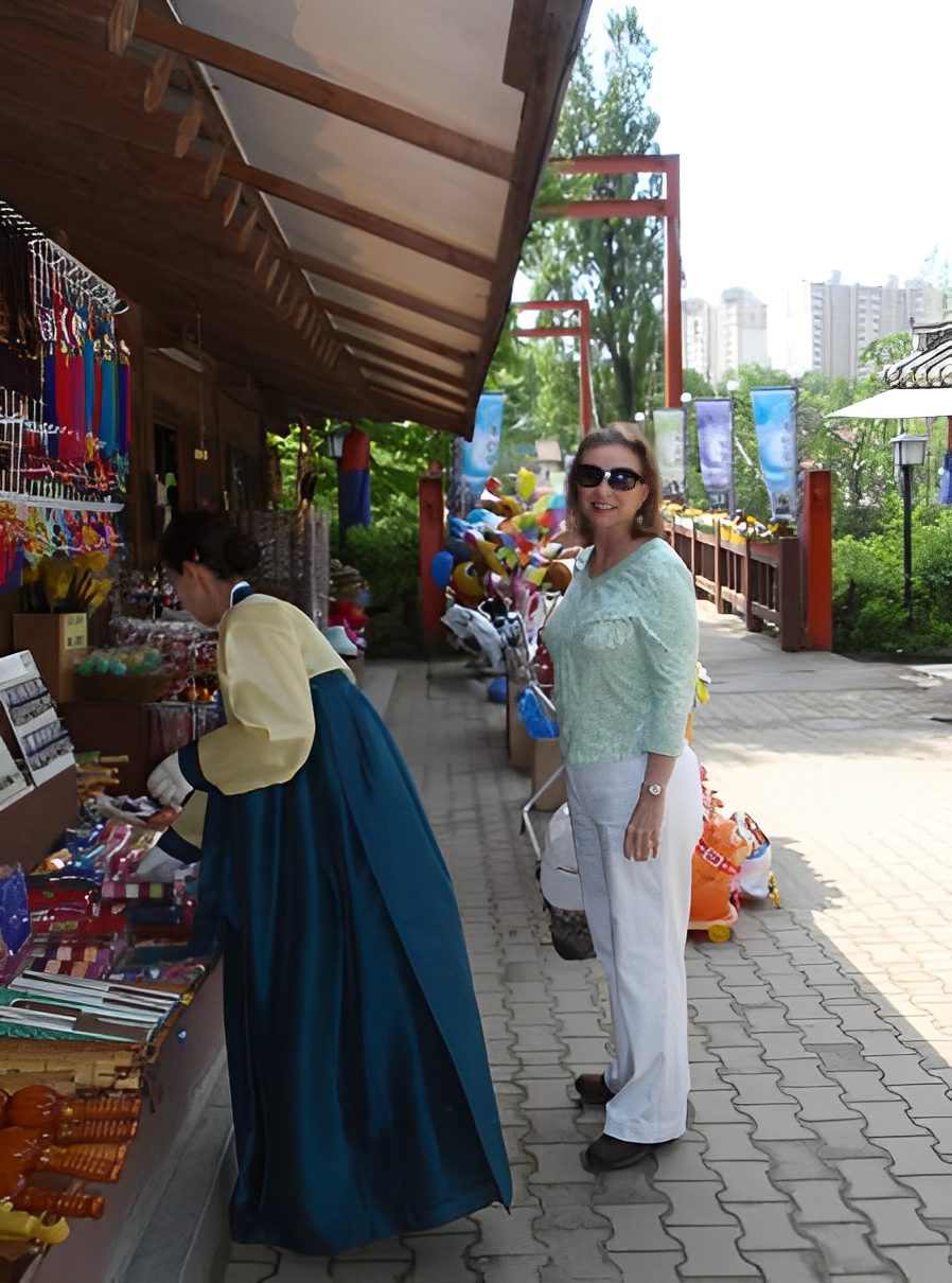 Woman shopping at outdoor market stall.