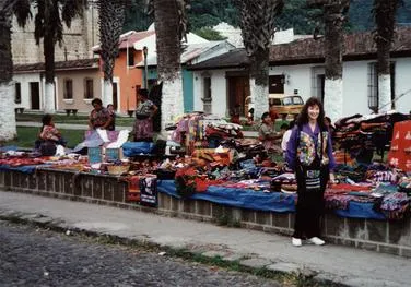 Outdoor market with colorful textiles and people.