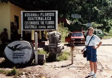 Person standing by Guatemalan customs sign outdoors.