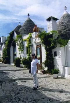 Person standing by traditional white stone houses.