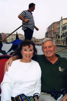 Couple on gondola ride in Venice canal.