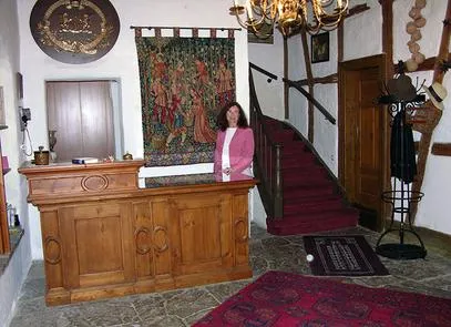 Woman standing in rustic hotel reception area.