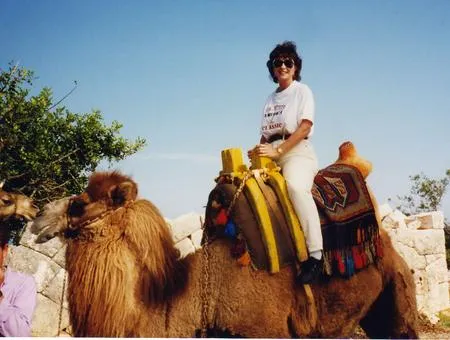 Person riding a camel under clear sky.