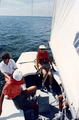 Sailboat with people on open water.