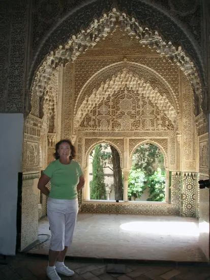 Person standing in ornate architectural archway.