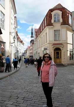 Woman standing on a cobblestone street.