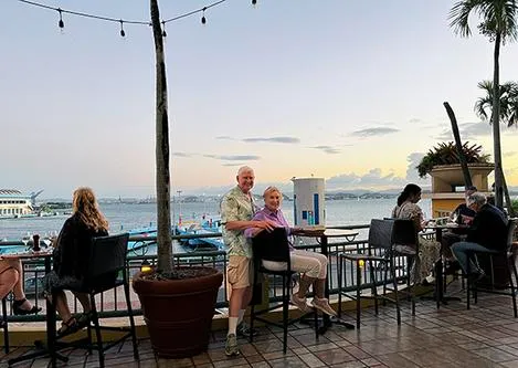 Couple enjoying seaside restaurant view at sunset.