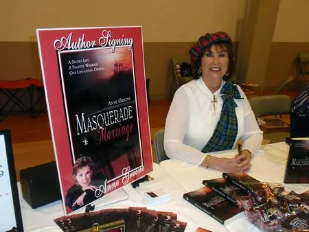 Author signing books at event table.