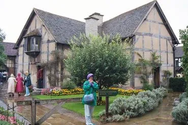 Historic timber-framed house with surrounding garden.