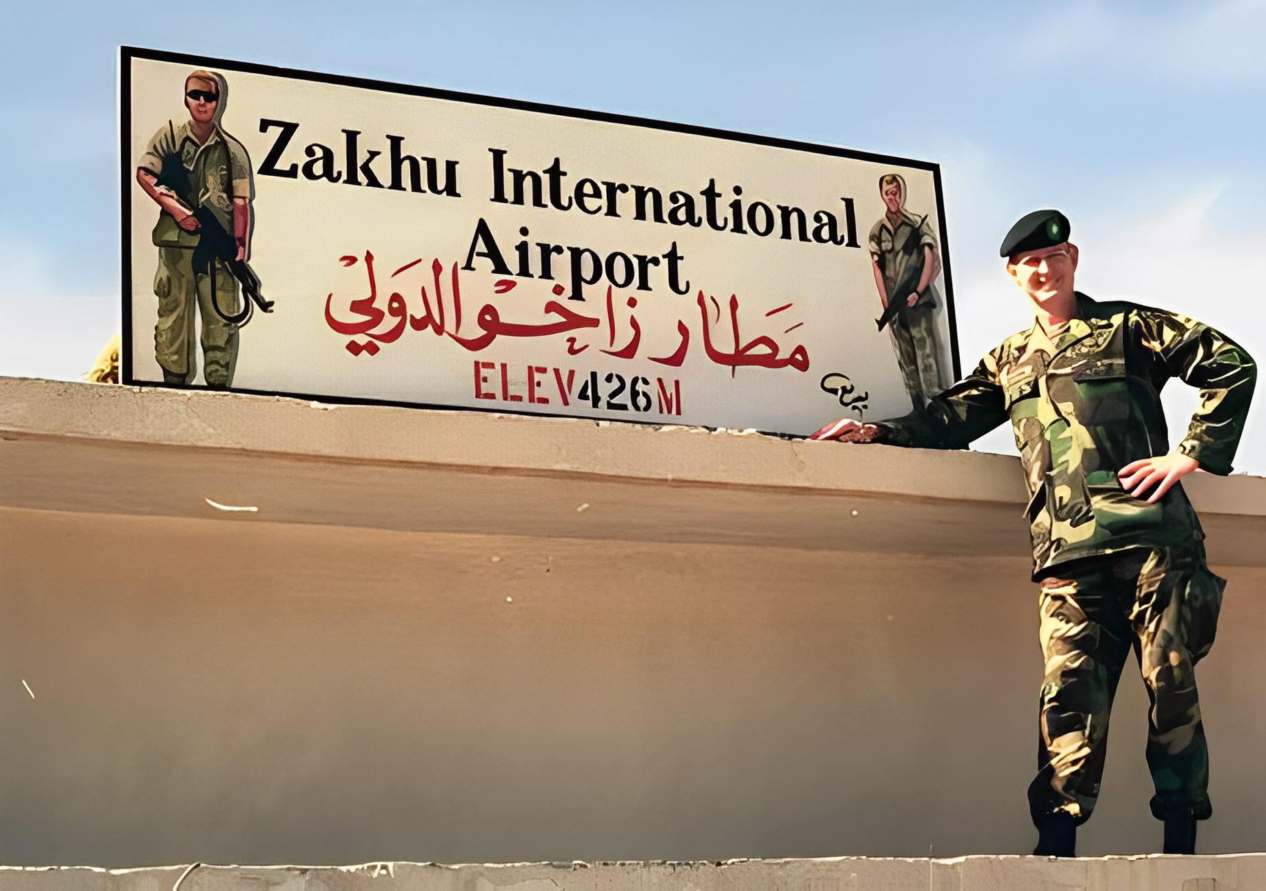 Soldier posing by Zakhu International Airport sign.