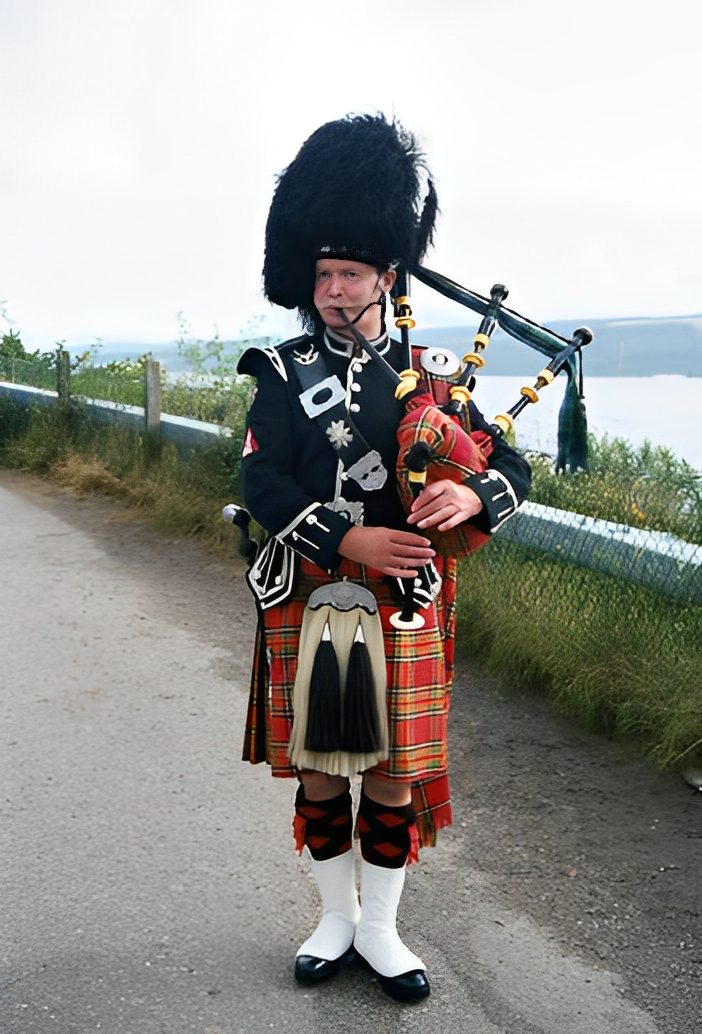 Bagpiper in traditional Scottish attire outdoors.