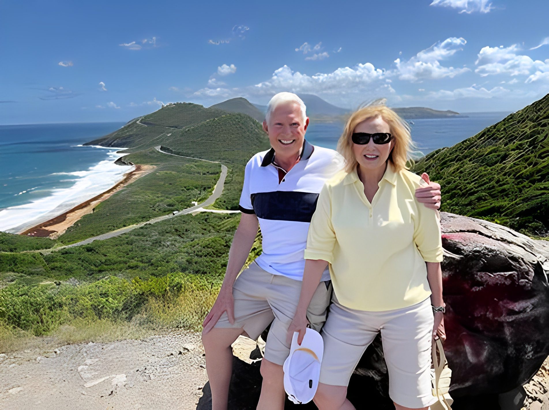 Couple posing on scenic coastal viewpoint.