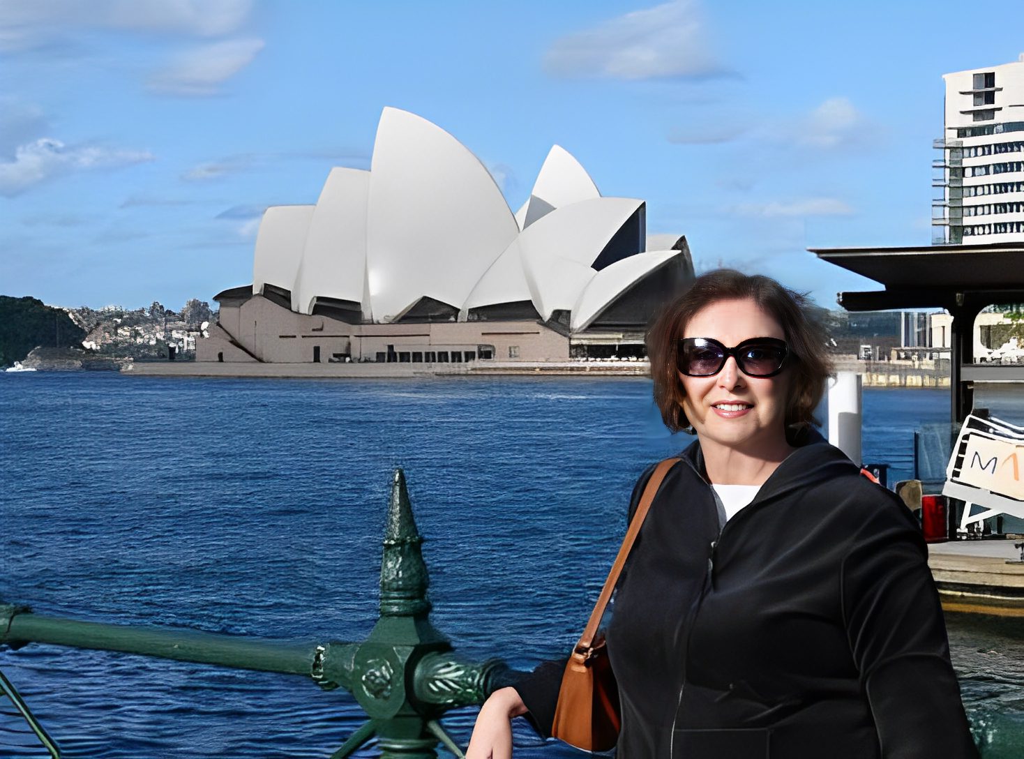 Woman smiling near Sydney Opera House.